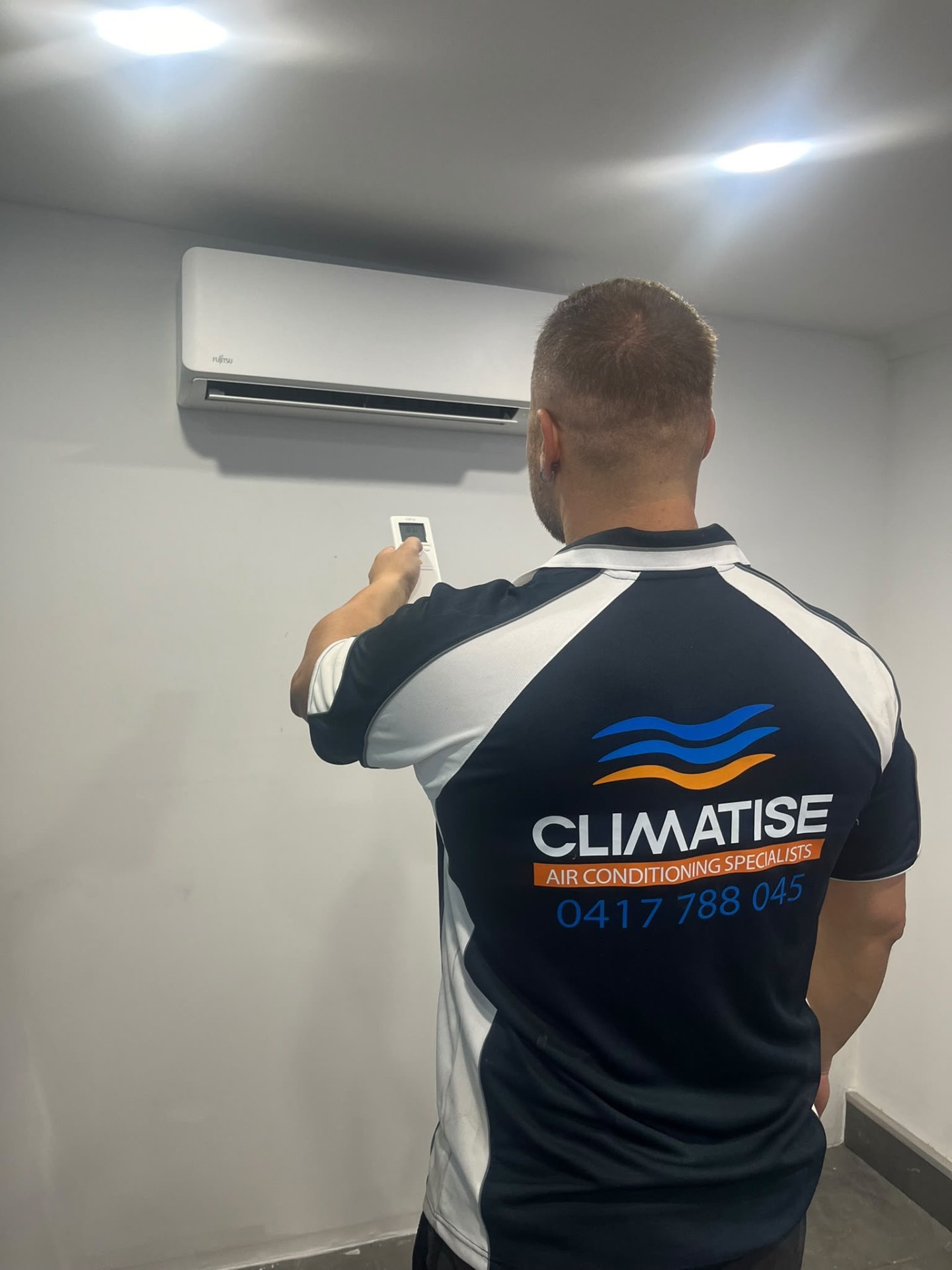 Christos Patsaras servicing an air conditioner